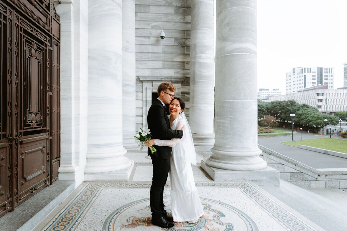 Couple embracing among marble columns in Wellington