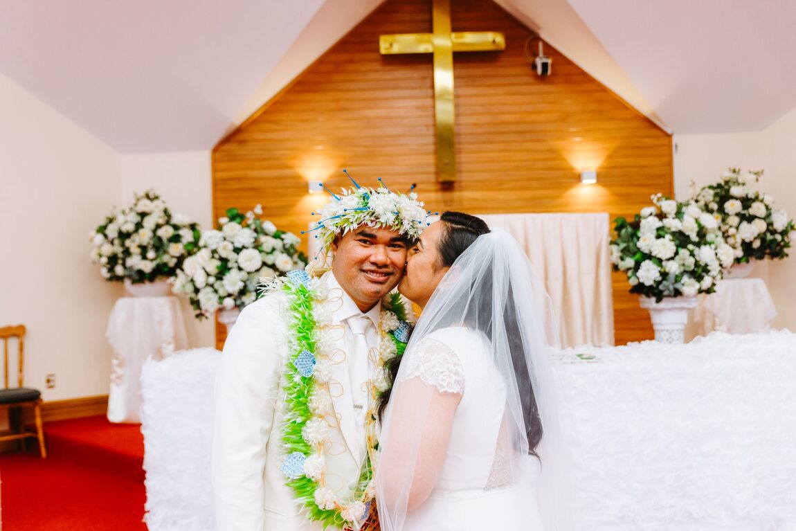 Couple sharing a kiss at the front of a church