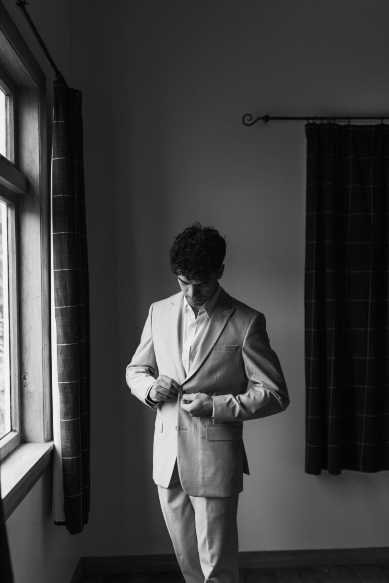 Groom getting ready by a window, black and white