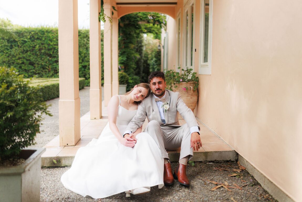 Couple seated together on the steps of a heritage villa