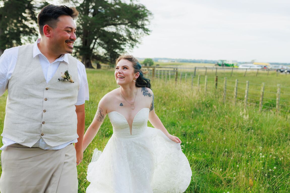 Couple walking together through a green paddock